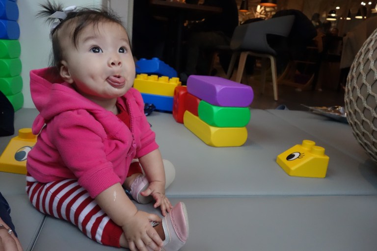 Another seven months milestone, besides sitting on her own, is blowing raspberries with her tongue out.
