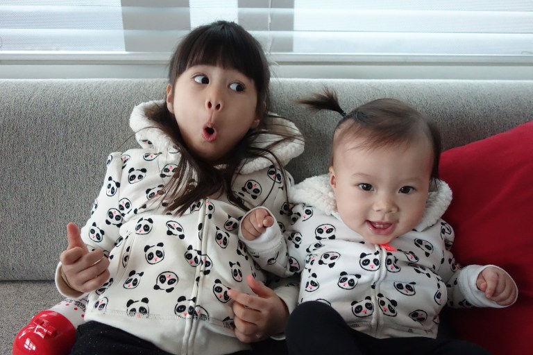 Isa and her big sister, Eva, in their matching hoodies before heading outside for some fun.