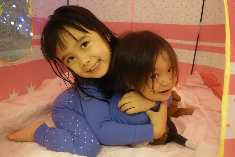 Eva is trying to hug Isa but it looks more like a headlock.